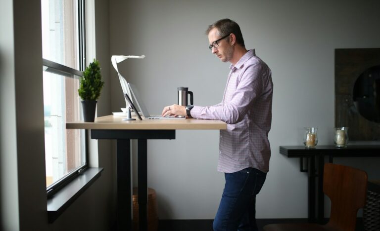 Person taking a brief walking break beside a comfortable computer workstation with relaxed posture.